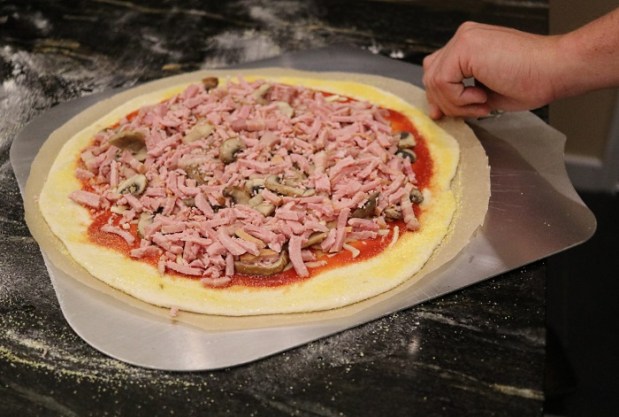 Use a pizza peel to slide the baking parchment into the oven