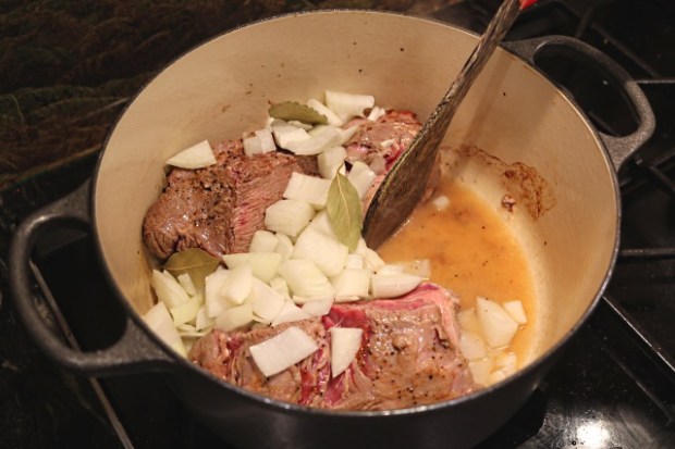 Stirring in the onion and bay leaves before adding other ingredients