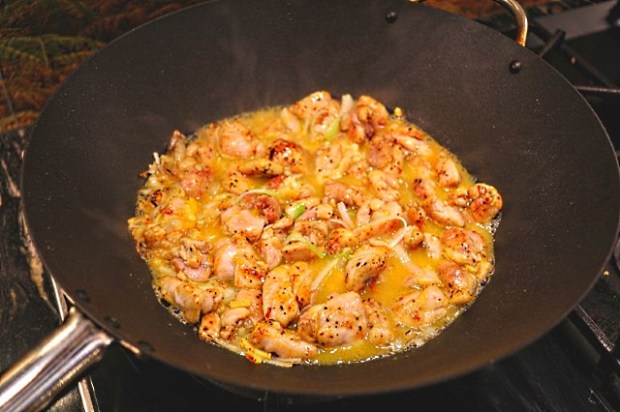 Simmering the chicken pieces in orange juice