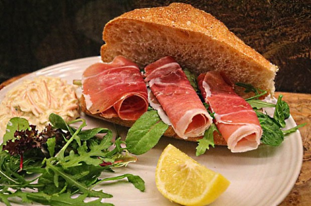 Crusty homemade baguette roll with meats, salad and coleslaw