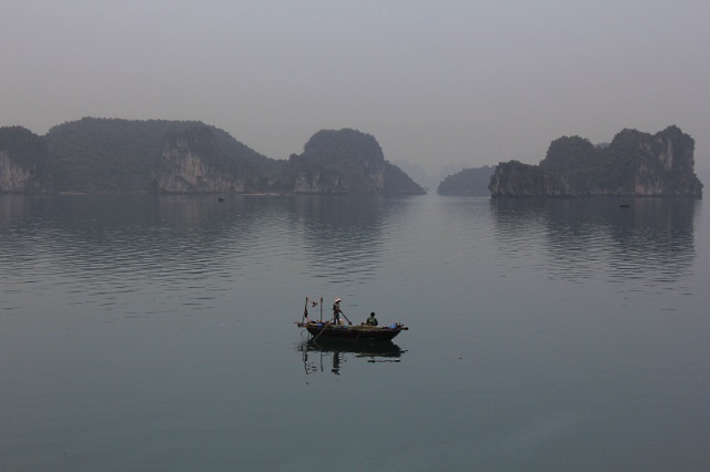 A fishing boat in the early morning mists of Halong Bay