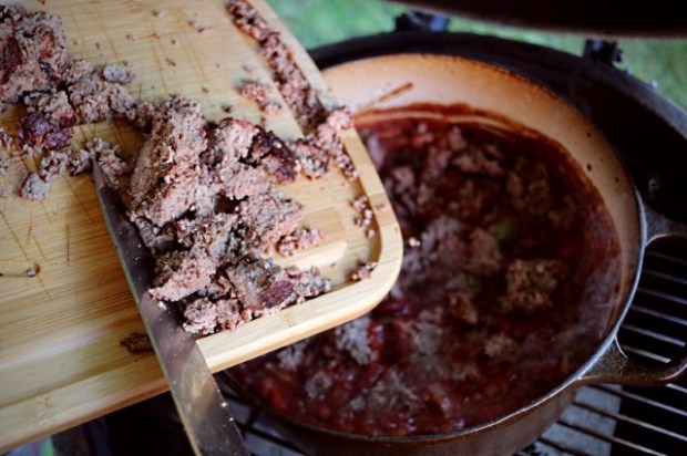 Adding chopped meat chunks into the chili to simmer some more