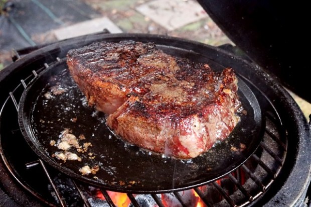 Searing rib-eye on a cast iron pan in melted bone marrow
