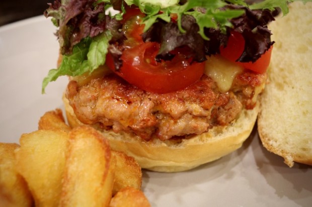 Pork and chorizo burger with toppings and chips