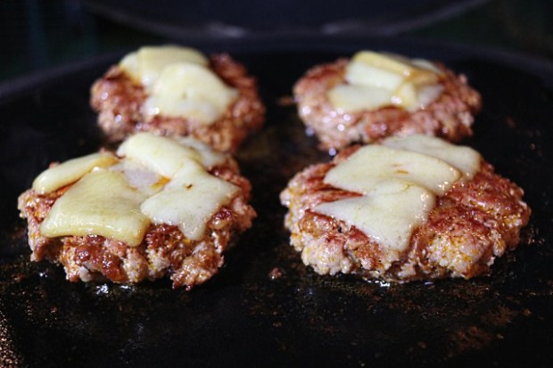 Melting smoked cheese into the burger