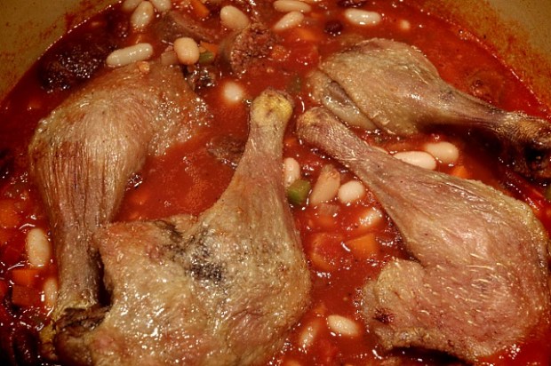 Duck legs and sausage chunks added to the dish