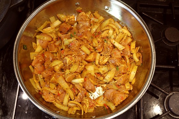 Chicken, sweet potato and onions frying in a pan