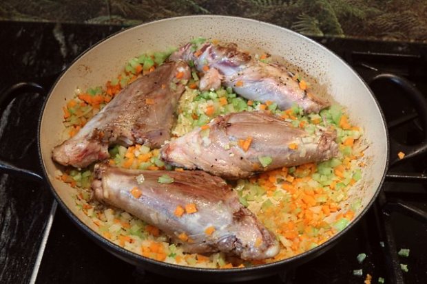 Lamb shoulder shanks browning with finely chopped vegetables