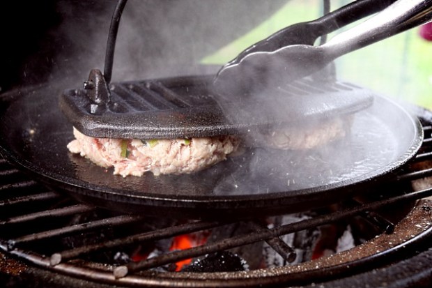 Smashing the burger balls with a meat press