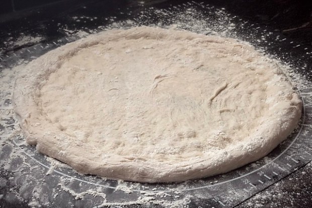 Pizza base shaped with air pushed to the edge for the crust