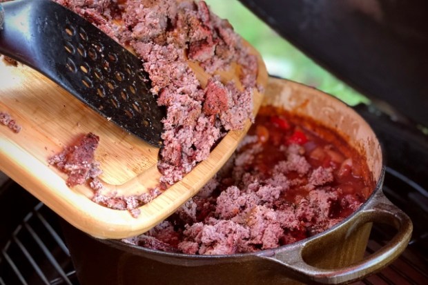 Adding the chopped meat into the chili