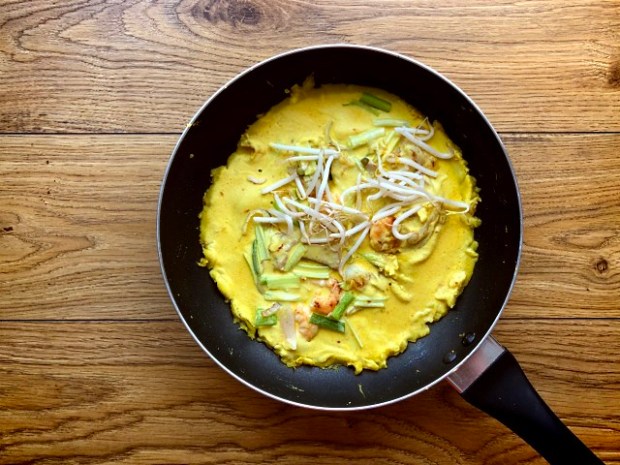 Batter mixture and beansprouts added into the pan