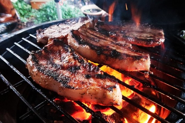 Marinated pork loin steaks cooking over charcoal